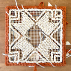 Locker Hooked pattern download. Decorative woven mat with a geometric pattern on a wooden surface