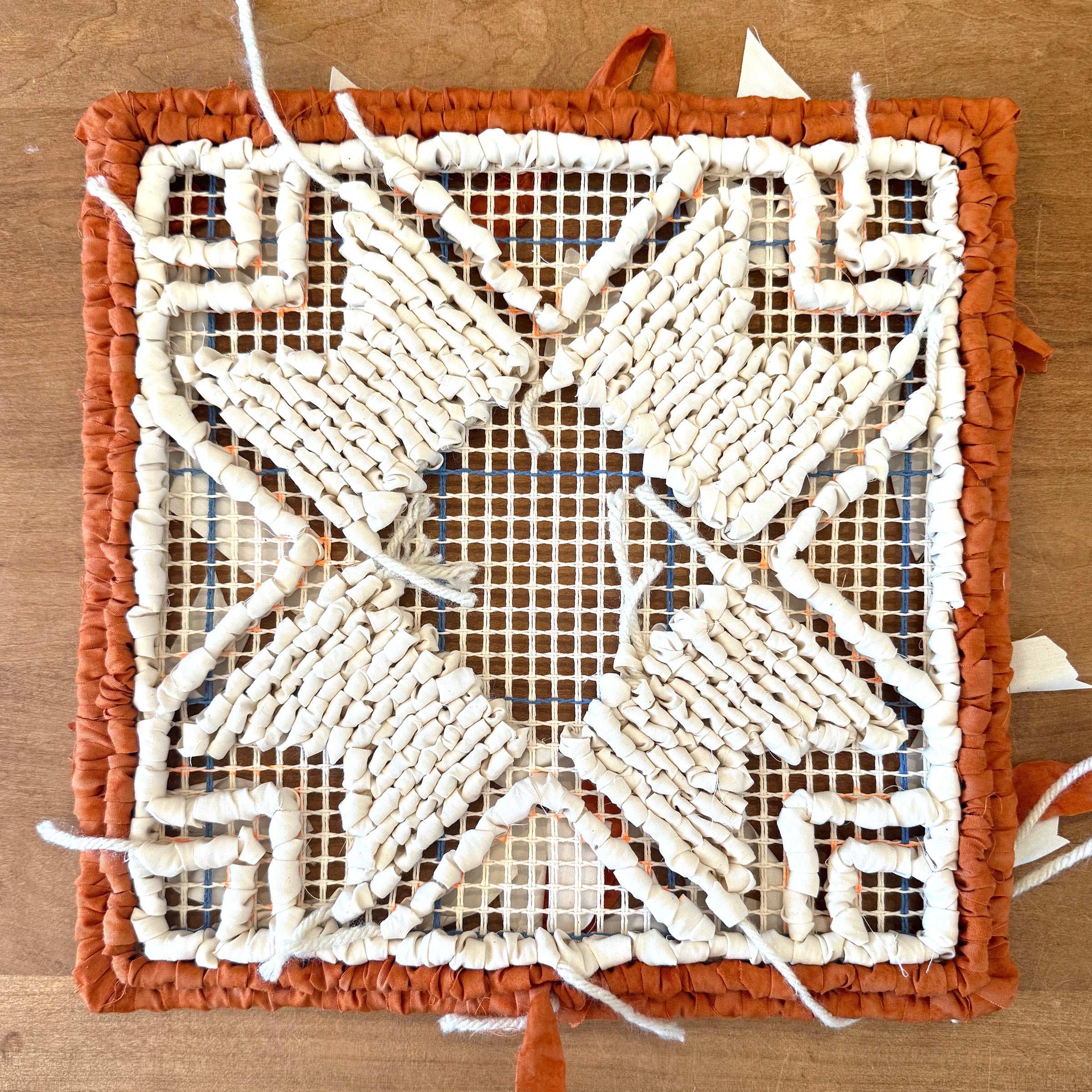 Locker Hooked pattern download. Decorative woven mat with a geometric pattern on a wooden surface