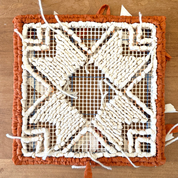 Locker Hooked pattern download. Decorative woven mat with a geometric pattern on a wooden surface